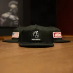 Black Warrior Makers classic trucker hat with the Spartan helmet and WARRIOR MAKERS patch on the front panel
