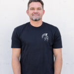 Man wearing the black Warrior Makers t-shirt with the Spartan helmet logo on the left chest