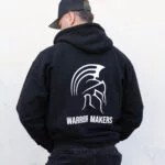 Back view of a man wearing the black Warrior Makers zip hoodie showing the Spartan helmet back print