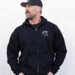 Man in a cap wearing the black Warrior Makers zip hoodie with the Spartan helmet logo on the chest