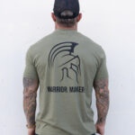 Back view of a man wearing the army green Warrior Makers t-shirt with the large Spartan helmet and WARRIOR MAKER back print