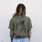 Back view of a woman wearing the army green Warrior Makers t-shirt showing the Spartan helmet back print