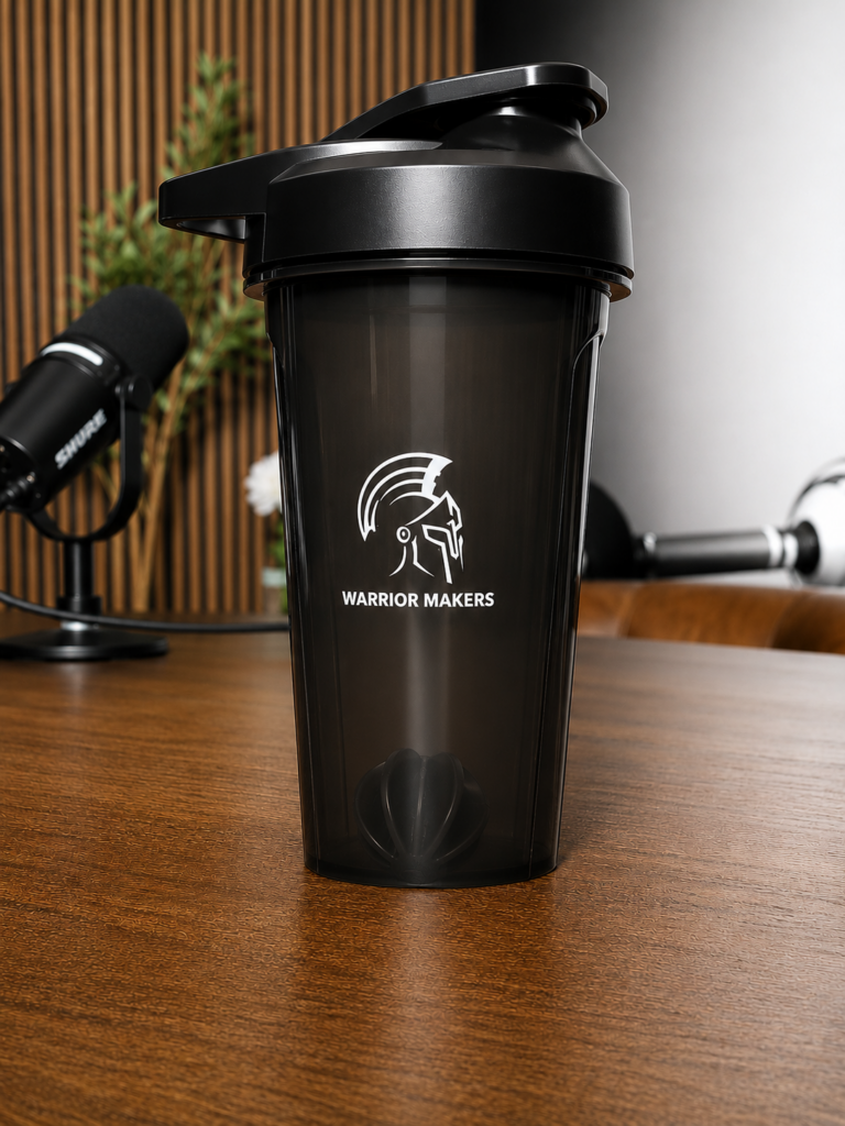 Black Warrior Makers shaker cup with the brand logo, standing on a wooden desk
