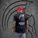 Back view of a man in a red cap wearing the black Warrior Makers PEPTIDES t-shirt with the large Spartan helmet and PEPTIDES back print